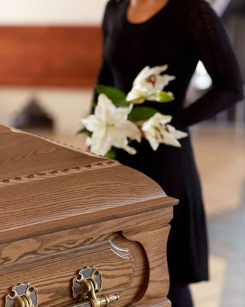 a woman stood by coffin at a funeral service