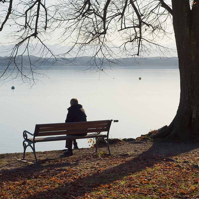sad person sitting on bench after partner has died